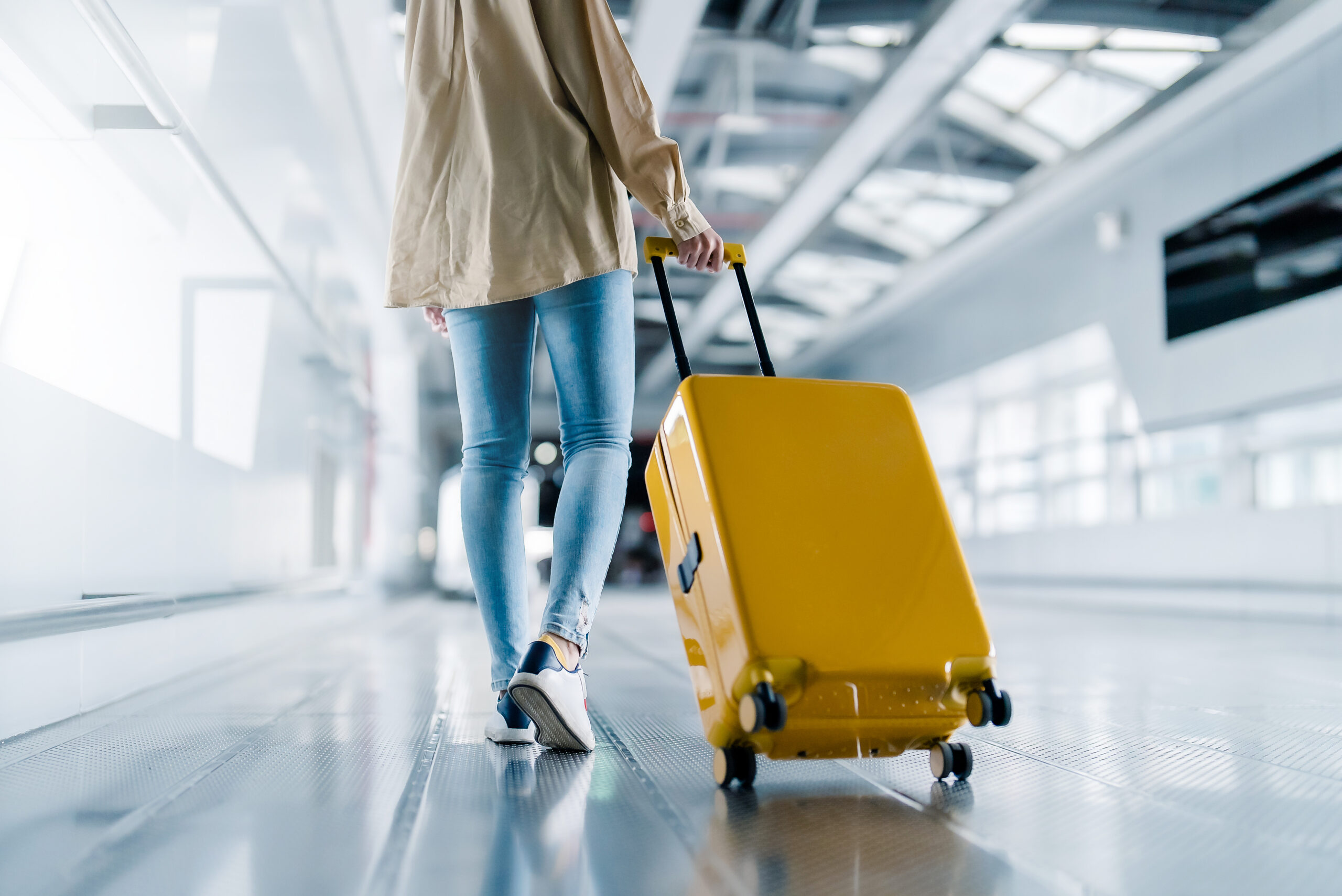 Women carrying luggage in airport for luxury airport transfer service