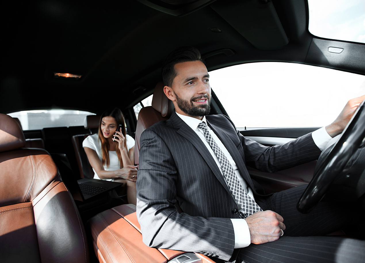 Professional chauffeur driving client for corporate transportation